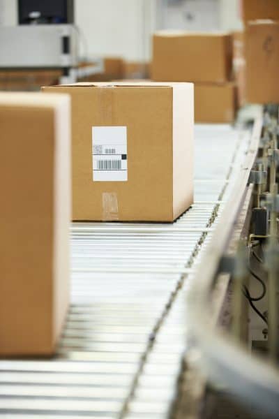 Goods On Conveyor Belt In Distribution Warehouse